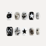 Flat lay of LOST in PARK Astro Courier short square press-on nails in black, white, and silver with star motifs, flames, graphic symbols, and 3D metallic studs.