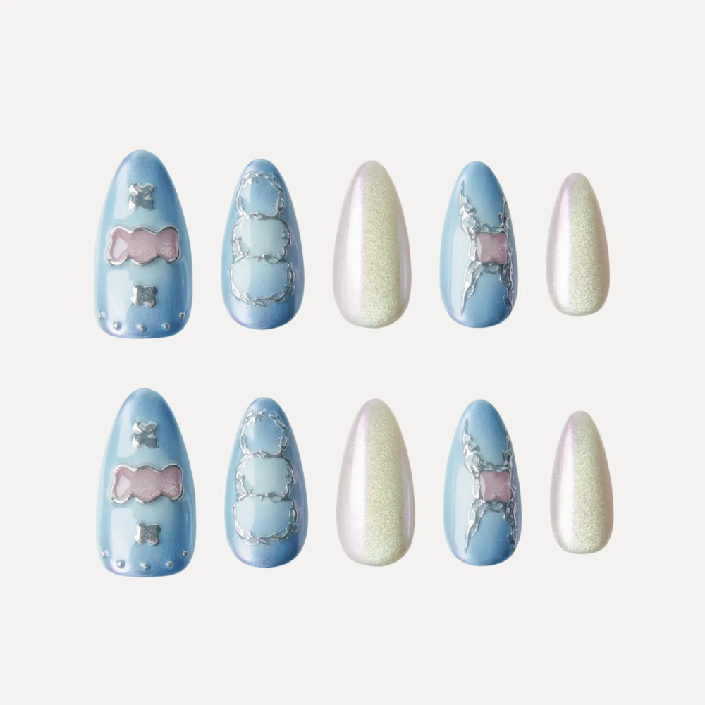 Medium almond press-on nail set in blue gradient and pearl shimmer with candy and outline motifs.
