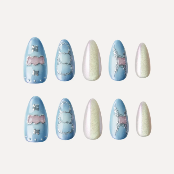 Medium almond press-on nail set in blue gradient and pearl shimmer with candy and outline motifs.
