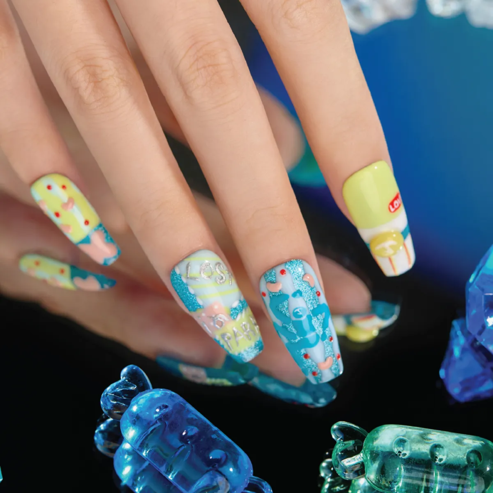 Candy Night long coffin press-on nails featuring glitter blue patterns, pastel yellow shapes, red dots, and LOST IN PARK text.