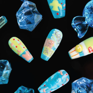 Flat lay of Candy Night long coffin press-on nails displayed among blue candy-like acrylic props.