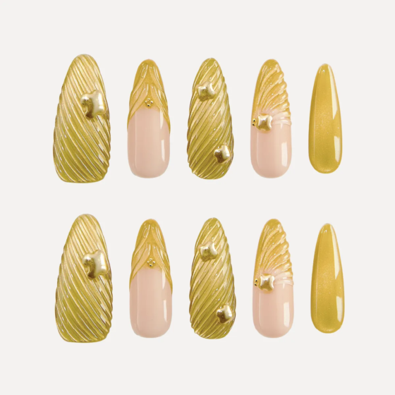 Chapter Gold long almond press-on nail set featuring metallic ribbed gold nails, nude gradient nails, and 3D gold studs arranged in two rows.
