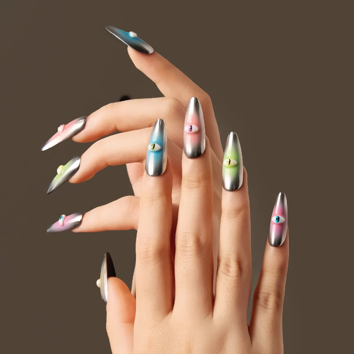 Side-angle view of the “Cosmic Vigil” nails highlighting the chrome shine and bold cartoon eye accents in contrasting neon shades.