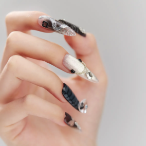 Artistic side-angle view of Cyber Pulse long stiletto nails highlighting sculpted silver designs and transparent pointed tips