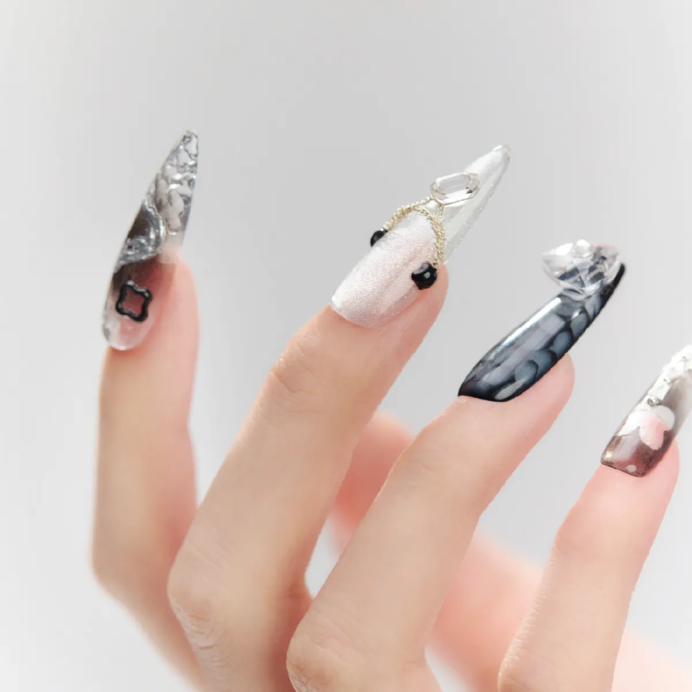 Detailed view of Cyber Pulse stiletto nails with gradient metallic finishes, 3D chain decorations, and bold chrome elements