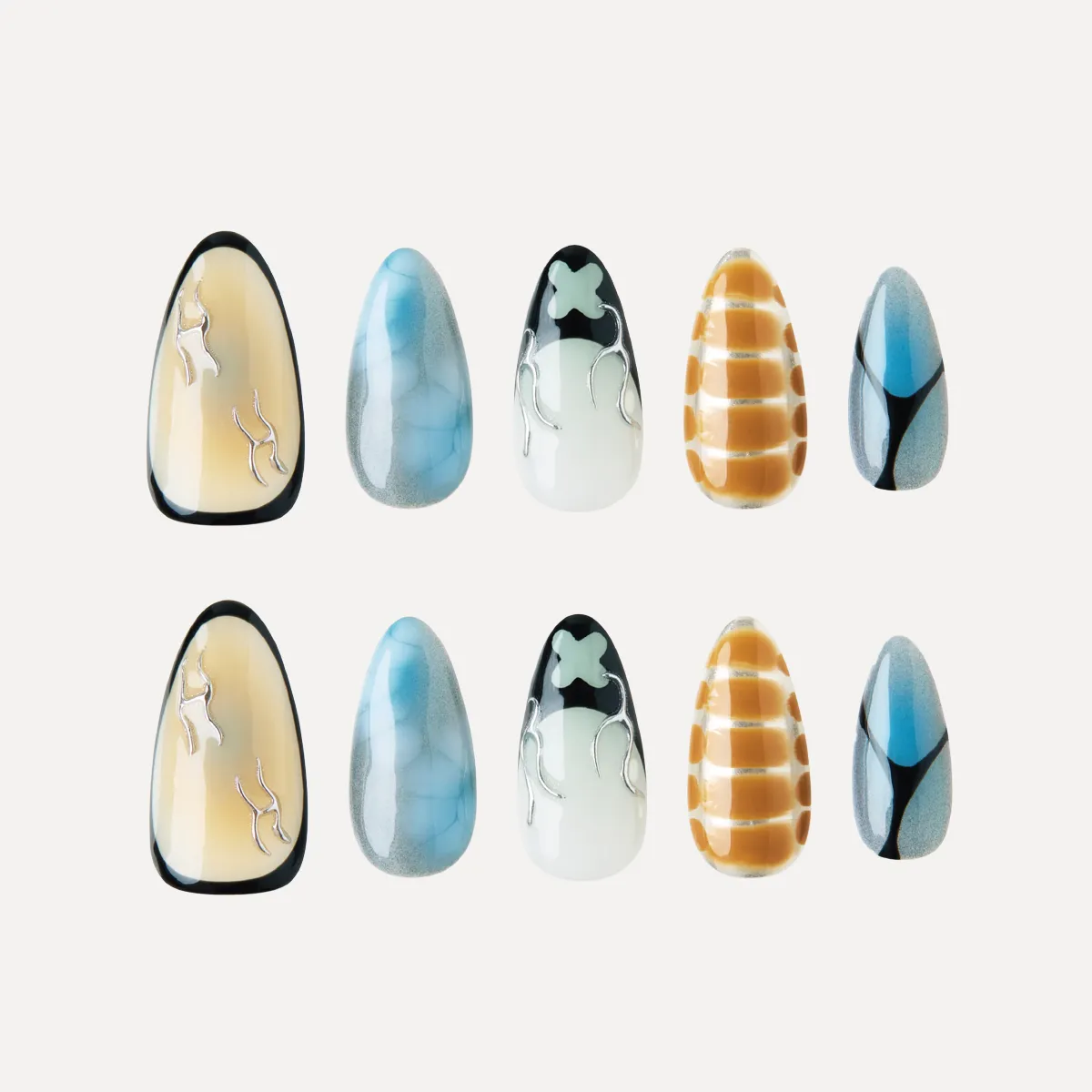 Flat lay of Deconstruct Vision press-on nail tips featuring abstract lines, smoky blue textures, yellow grid print, and black-white flame motifs