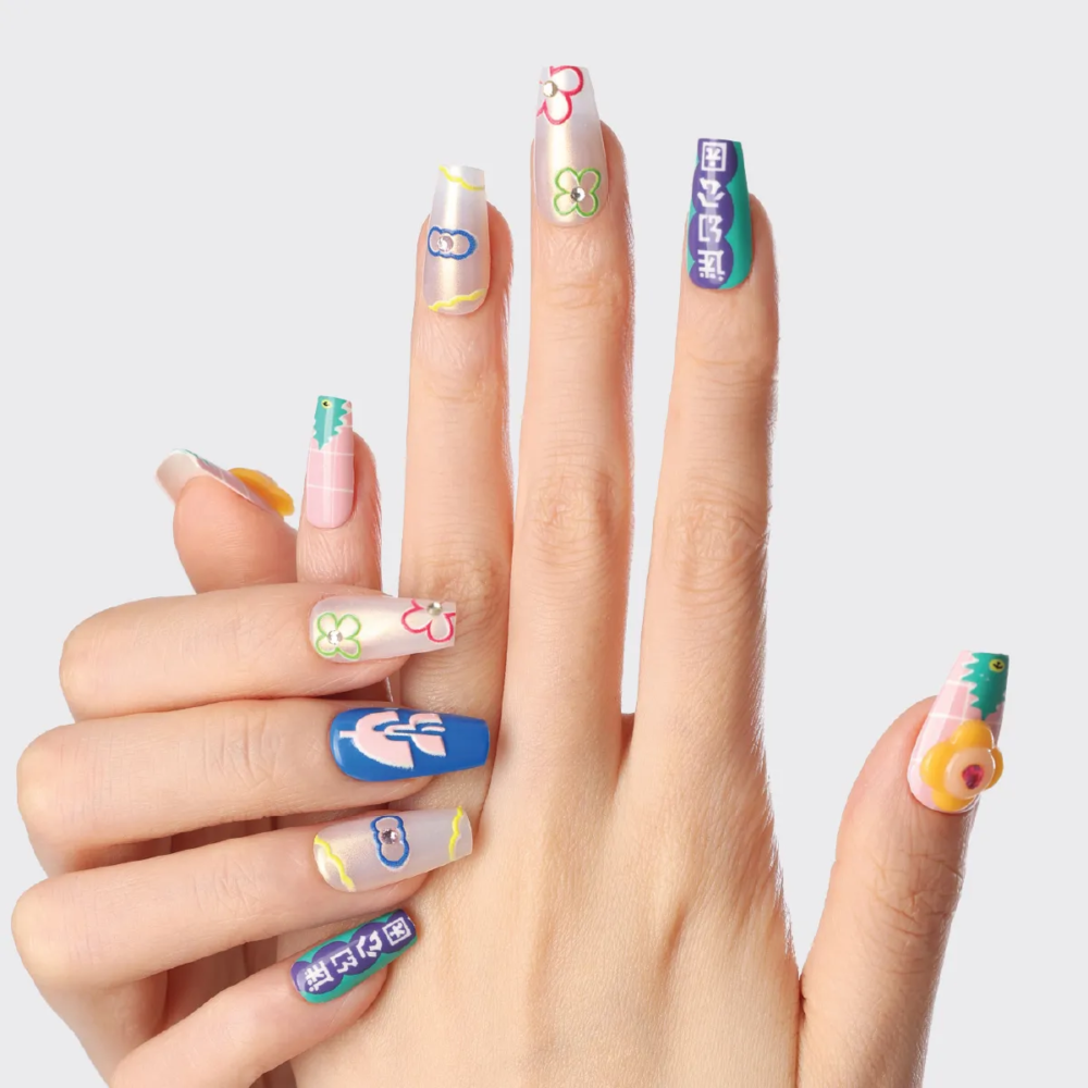 Hand wearing colorful Flower Bazaar press-on nails with mixed floral and graphic designs