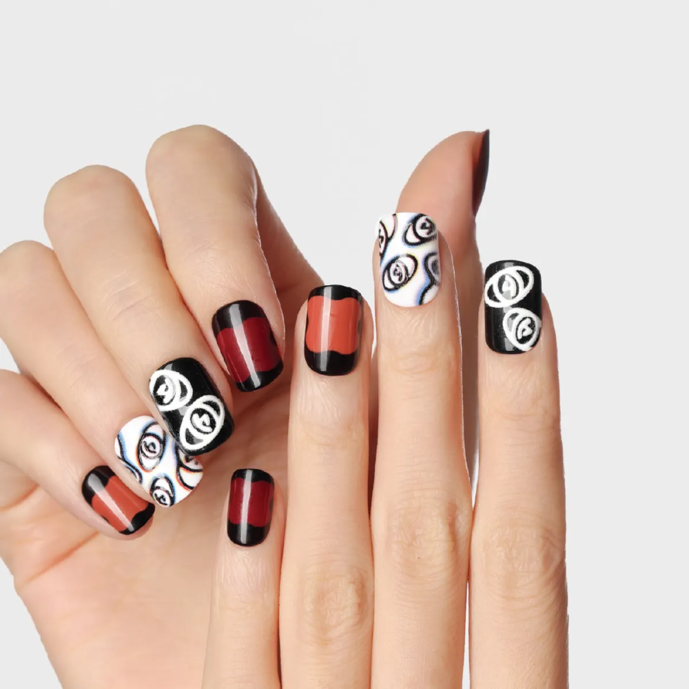 plum rhapsody press-on nails in deep red and black tones with abstract white eye illustrations and gradient effects on fingers.
