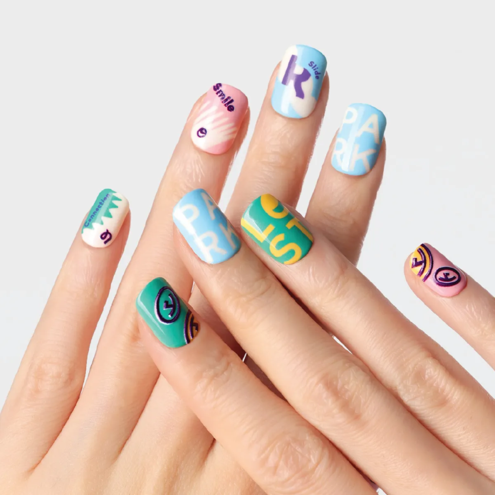 Diagonal hand arrangement showing vibrant mix of green, pink, blue and yellow nail designs