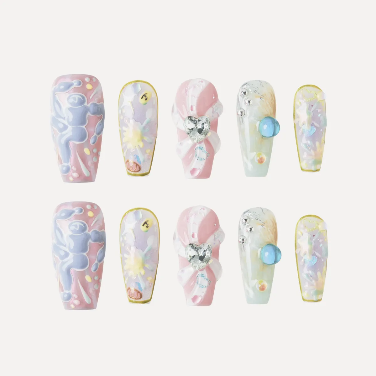 Full Sweet Dream Bomb nail set (10 pieces) laid flat showing pastel designs, 3D hearts, and gem embellishments.