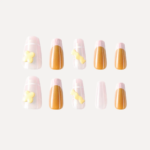 Set of long almond press-on nails with pink grid design, gold metallic tips, and yellow 3D candy decorations arranged in two rows.
