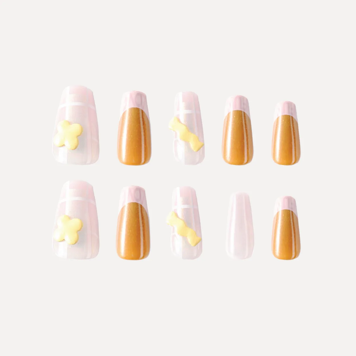 Set of long almond press-on nails with pink grid design, gold metallic tips, and yellow 3D candy decorations arranged in two rows.