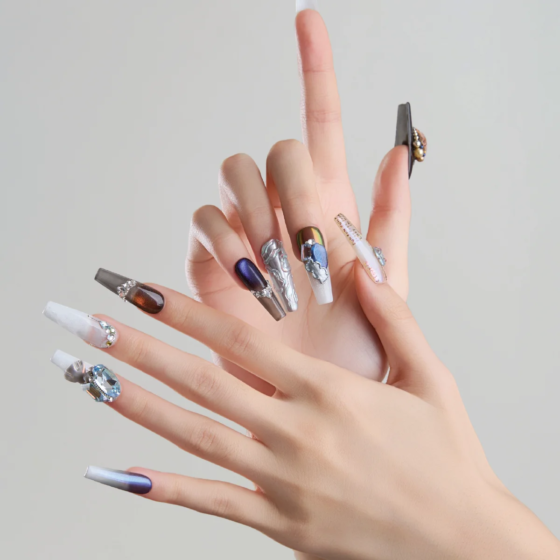 Long coffin press on nails worn on hands with dark metallic chrome and sculptural 3D designs