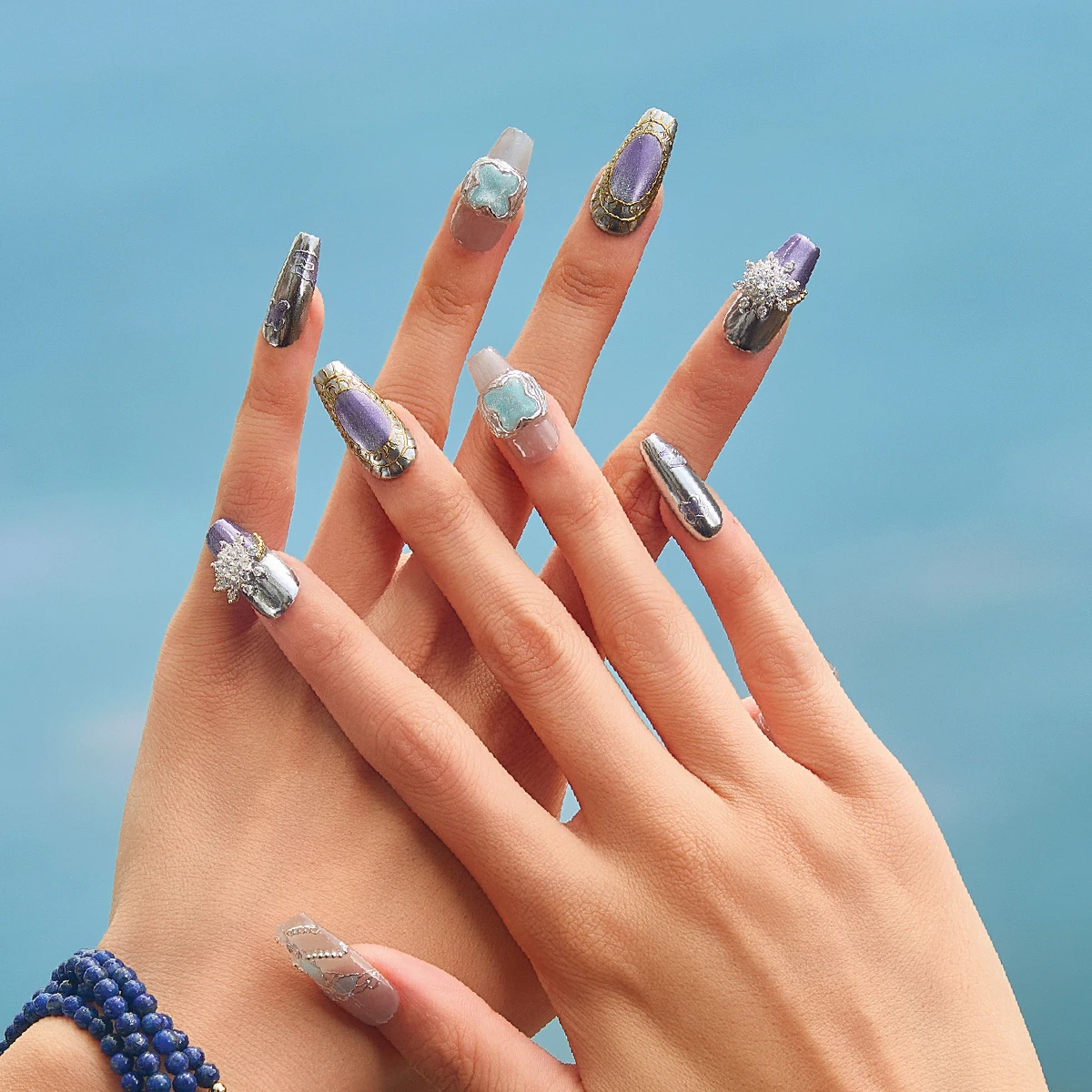 Luxury gemstone-inspired press-on nails worn on hands